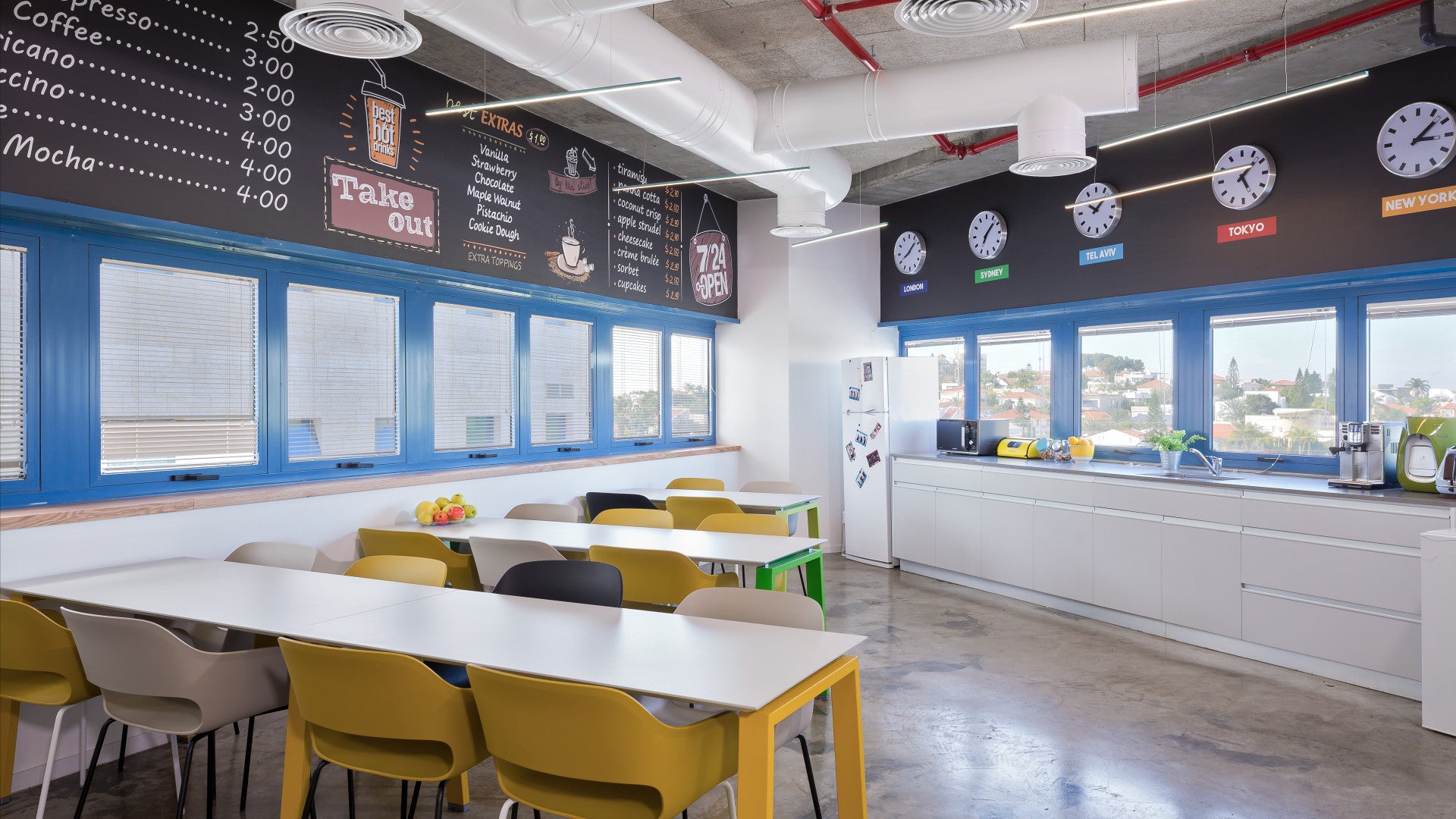 Modern kitchen and dining space at Foto Master with coffee-themed decor, clocks, and seating for employees.