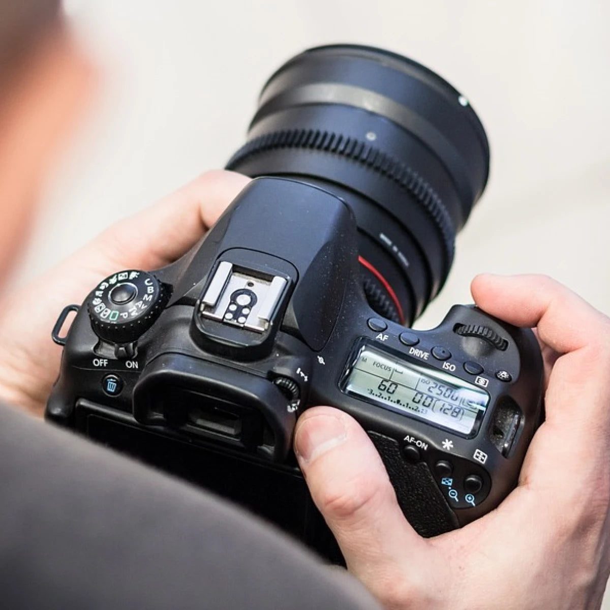DSLR camera in hand - showing that photo booths are offered & suitable for photographers.