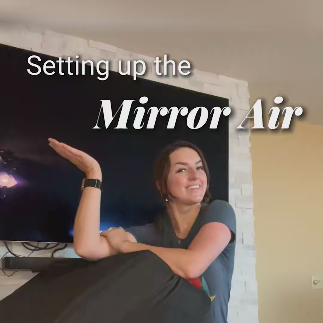 Smiling woman with straight brown hair (Colleen Roden) gesturing toward Mirror Air photo booth during a setup tutorial.