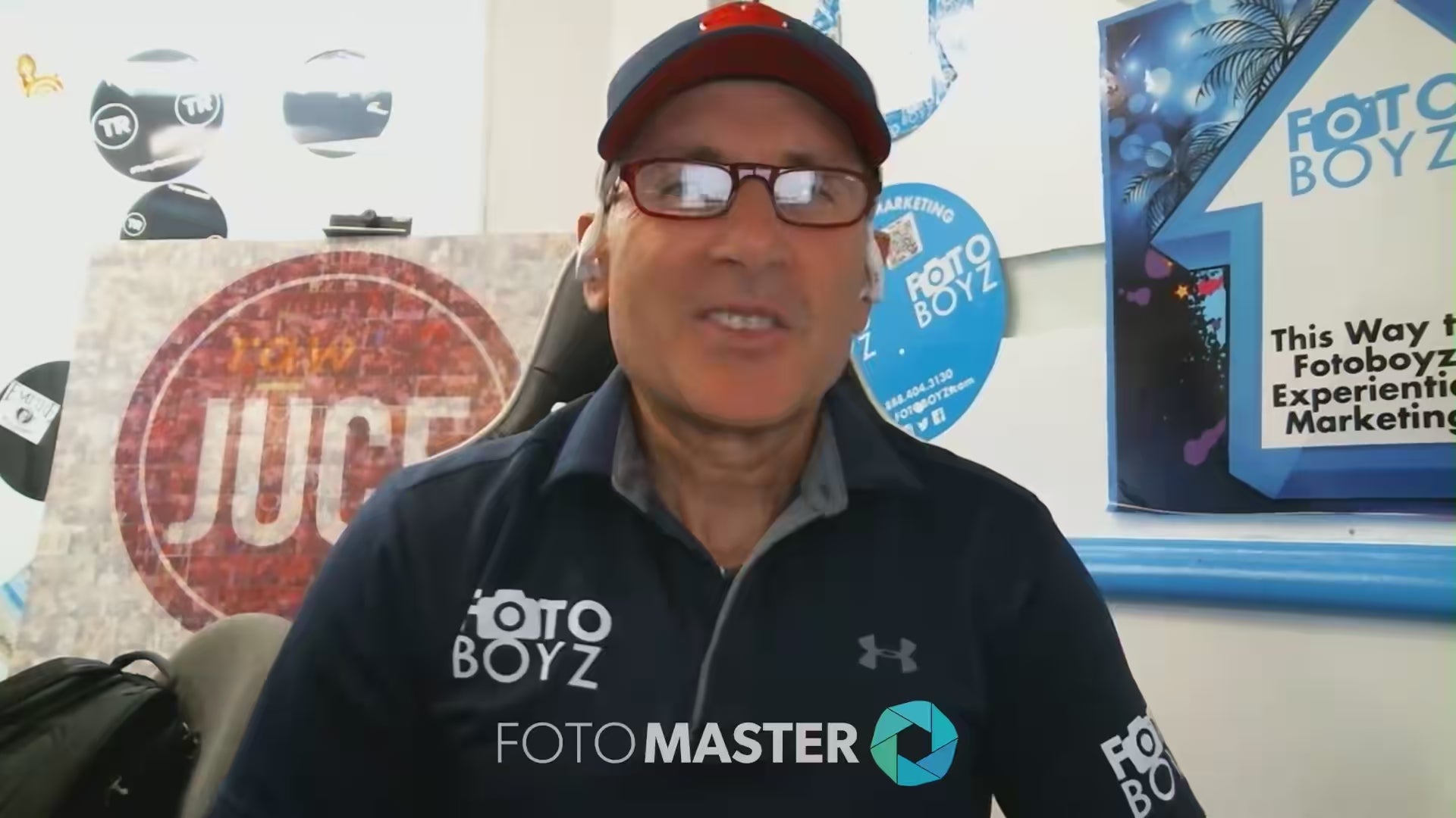 Philip Wexler of FotoBoyz speaking on camera with branded background during a Foto Master testimonial