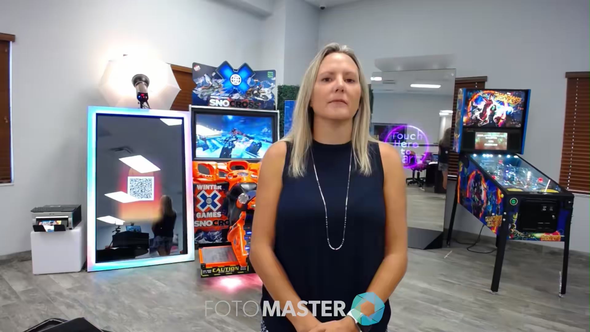 Luna Tolunay of Fun Planners standing in a game room with interactive photo booths by Foto Master
