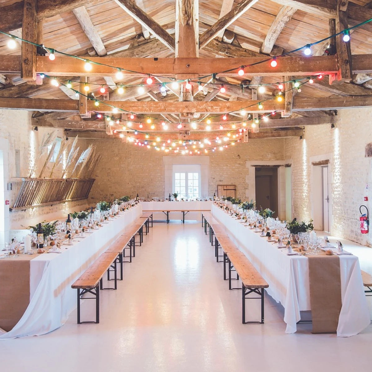 Stylish event venue with long tables and ambient lighting, ideal for photo booths